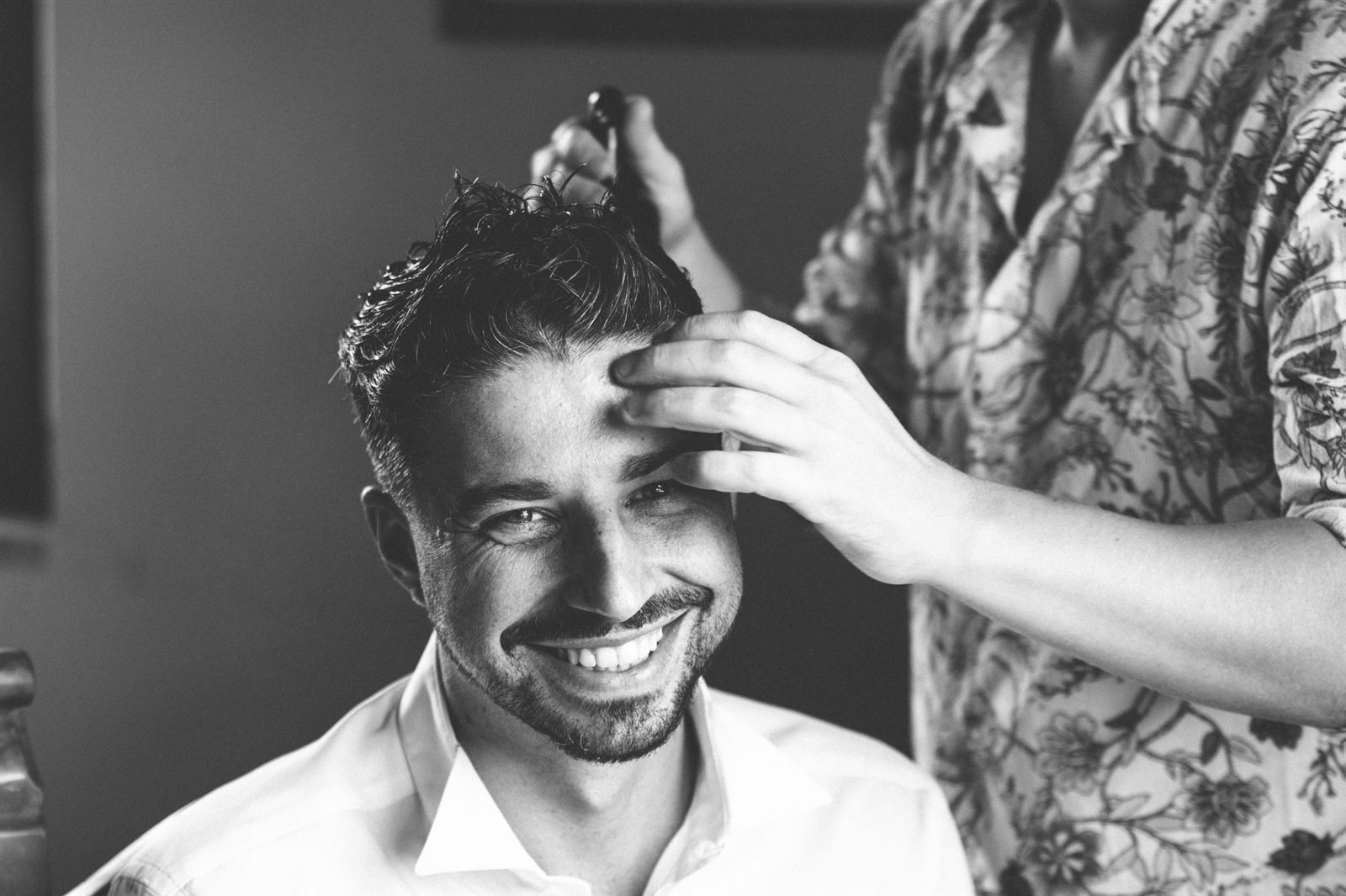 Lo sposo si acconcia i capelli sorridente, bianco e nero Lo sposo si acconcia i capelli sorridente, bianco e nero