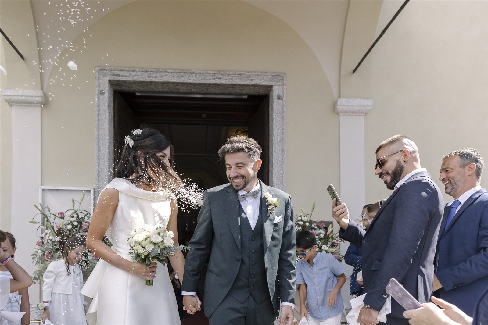 Facciata della chiesa con gli sposi che escono tra gli invitati
