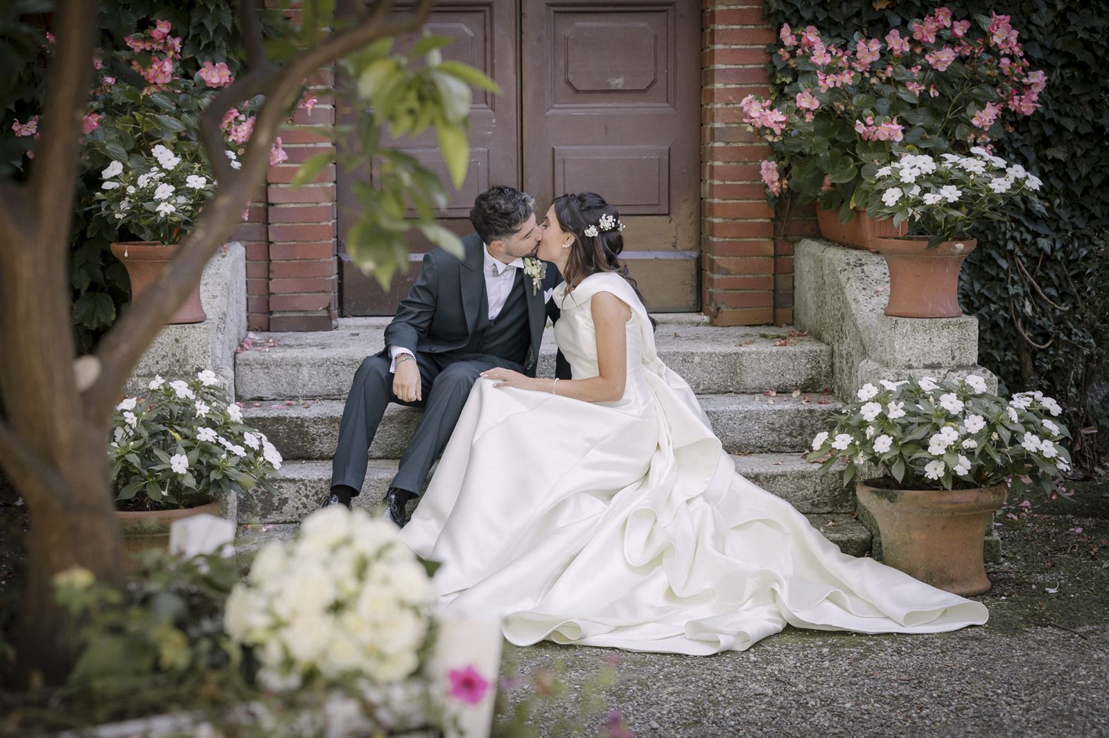 Gli sposi seduti sulla scalinata tra i fiori Gli sposi seduti sulla scalinata tra i fiori