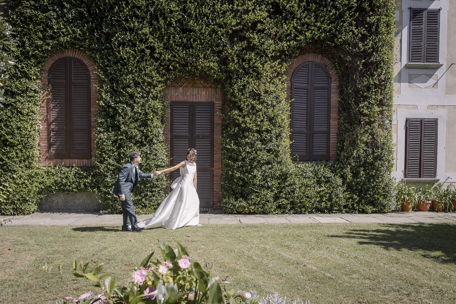 Gli sposi camminano nel giardino sotto gli alberi Gli sposi camminano nel giardino sotto gli alberi