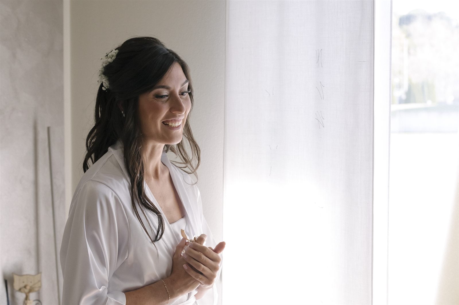La sposa sorridente controluce alla finestra La sposa sorridente controluce alla finestra