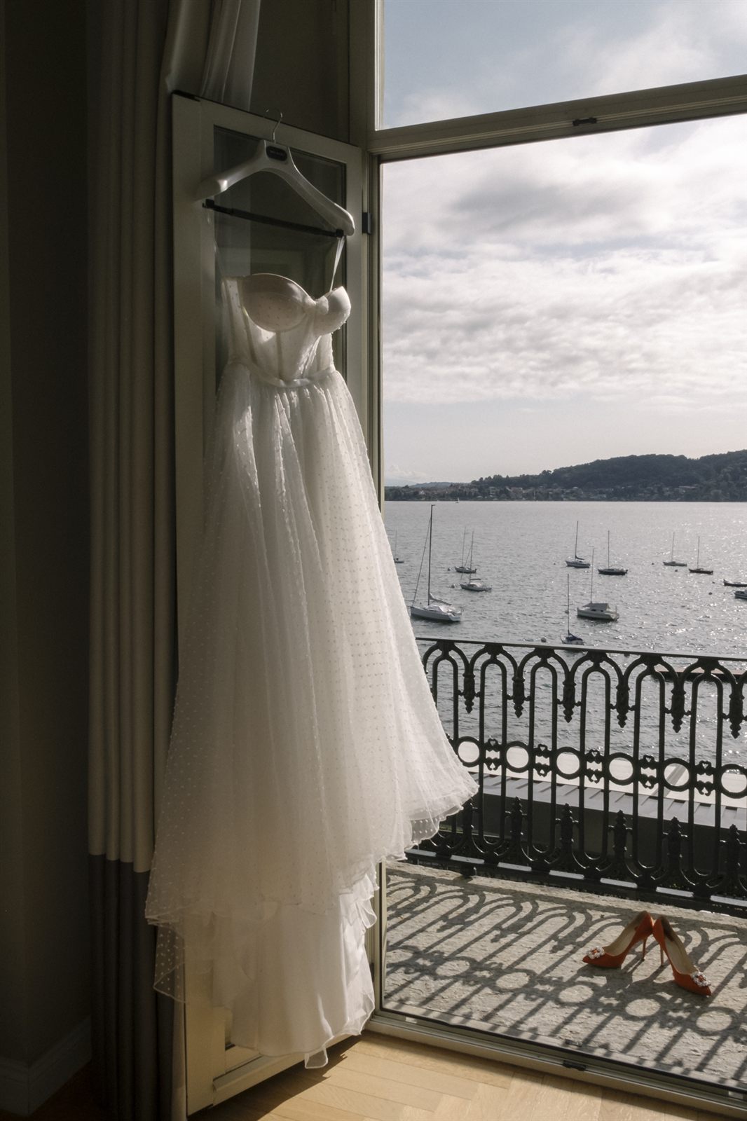 L'abito da sposa appeso alla finestra con vista sul lago L'abito da sposa appeso alla finestra con vista sul lago