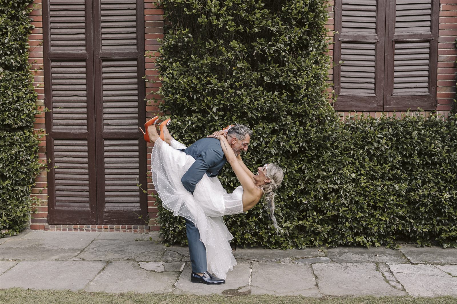 Lo sposo solleva la sposa davanti al portone d'ingresso Lo sposo solleva la sposa davanti al portone d'ingresso