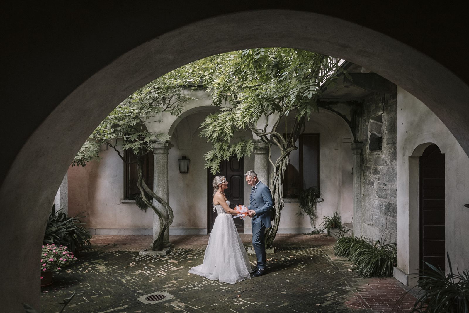 Gli sposi sotto l'arco in pietra del cortile Gli sposi sotto l'arco in pietra del cortile