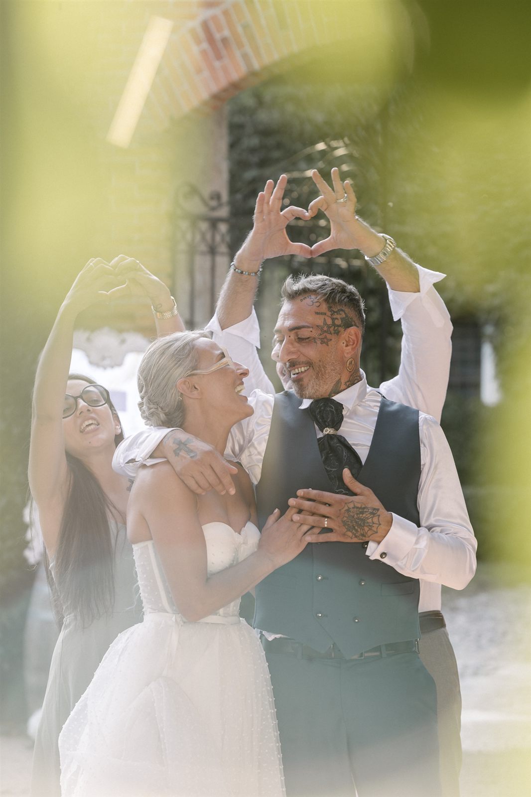 Gli sposi formano un cuore con le mani, controluce Gli sposi formano un cuore con le mani, controluce