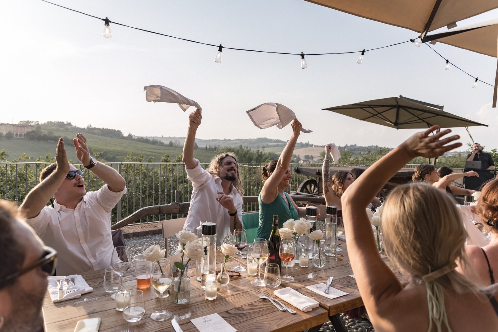 Guests waving their napkins at dinner on the terrace
