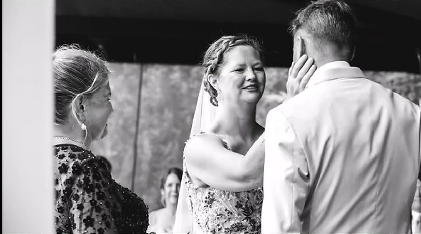 The bride cupping the groom's face during the ceremony