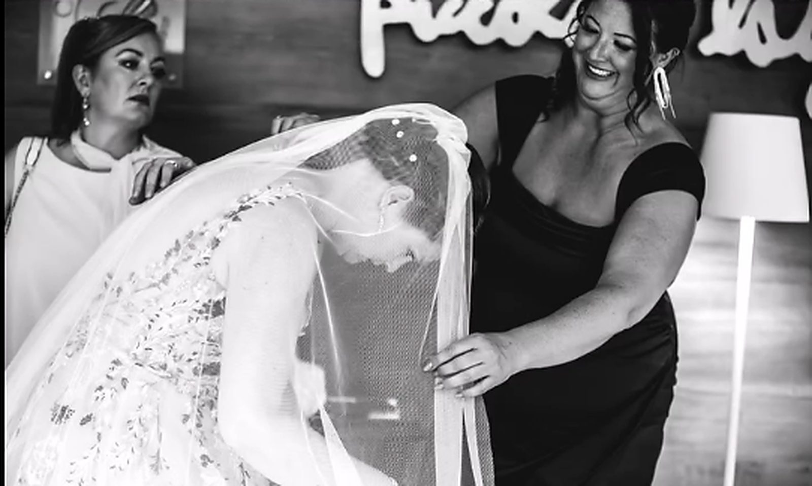 Two friends arranging the bride's veil, black and white