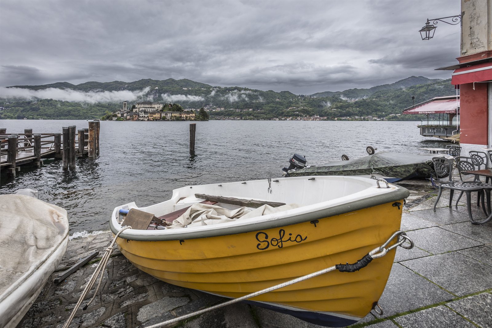 The yellow boat moored in front of Orta, the island in the background