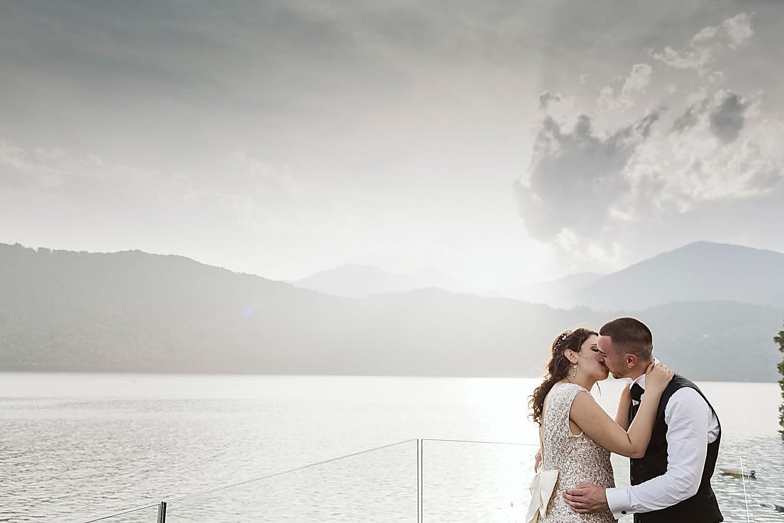 Il bacio sulla terrazza affacciata sul lago, controluce