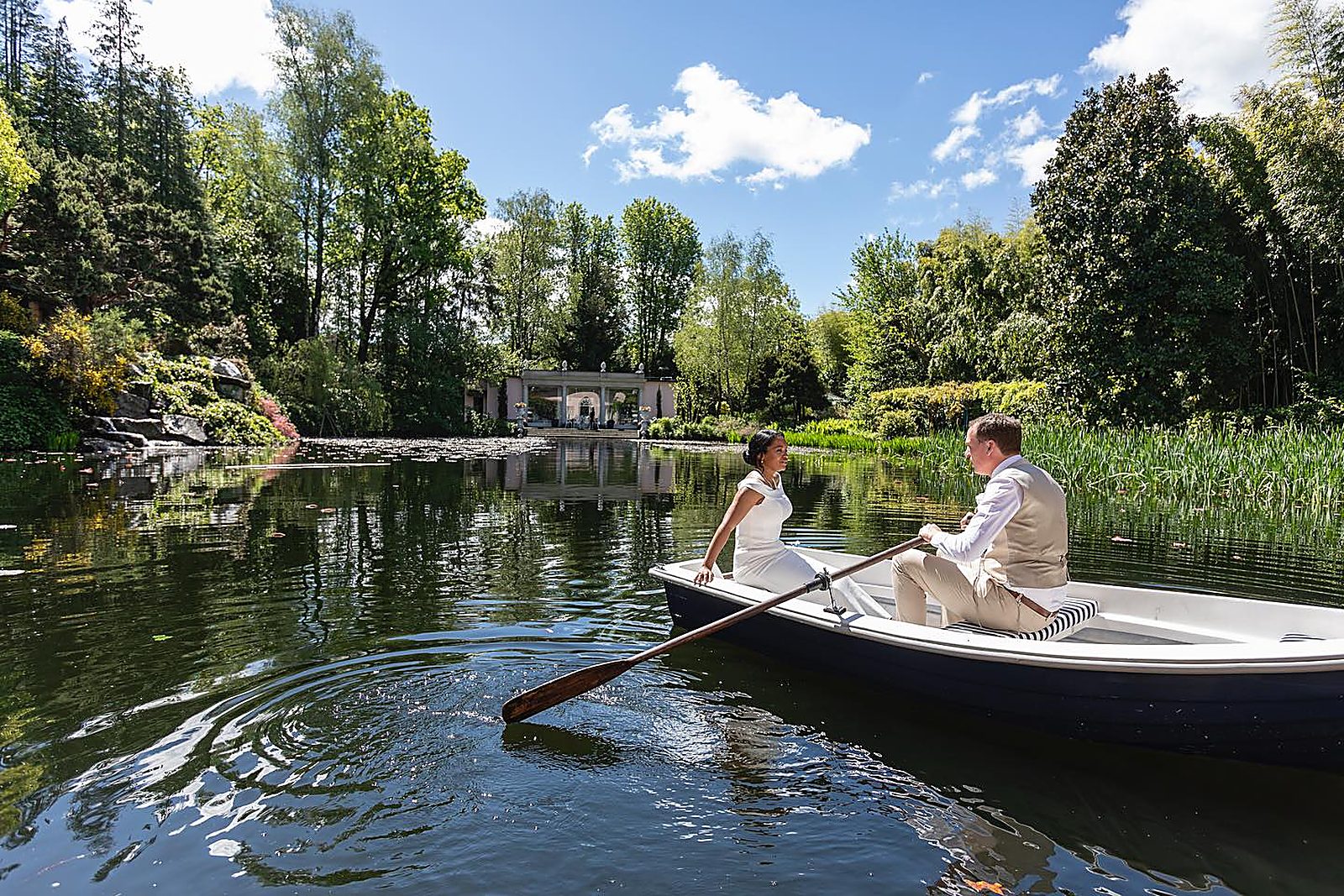 The newlyweds rowing on the private lake, towards the little temple