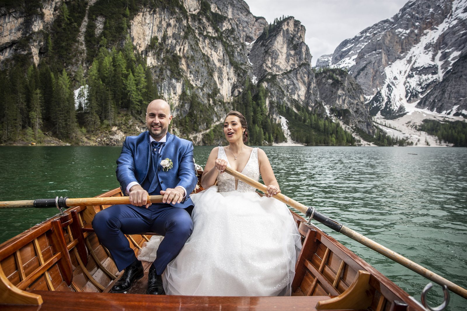 Gli sposi nella barca di legno, sull'acqua verde del lago