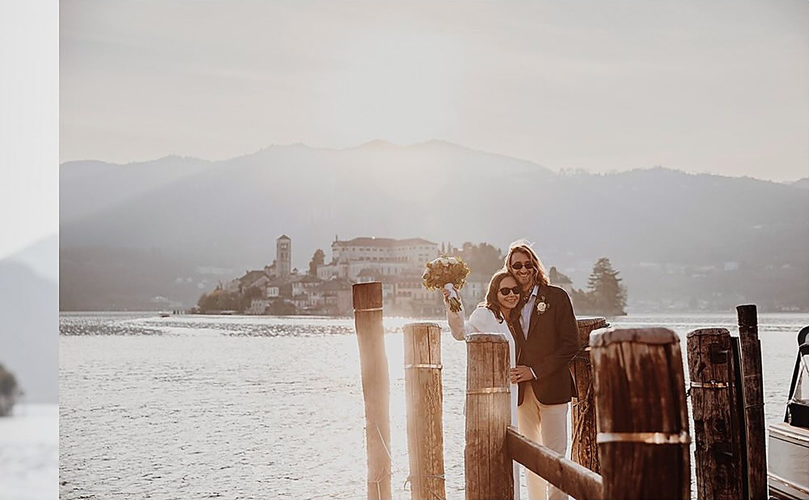 Gli sposi sul pontile con l'Isola di San Giulio controluce
