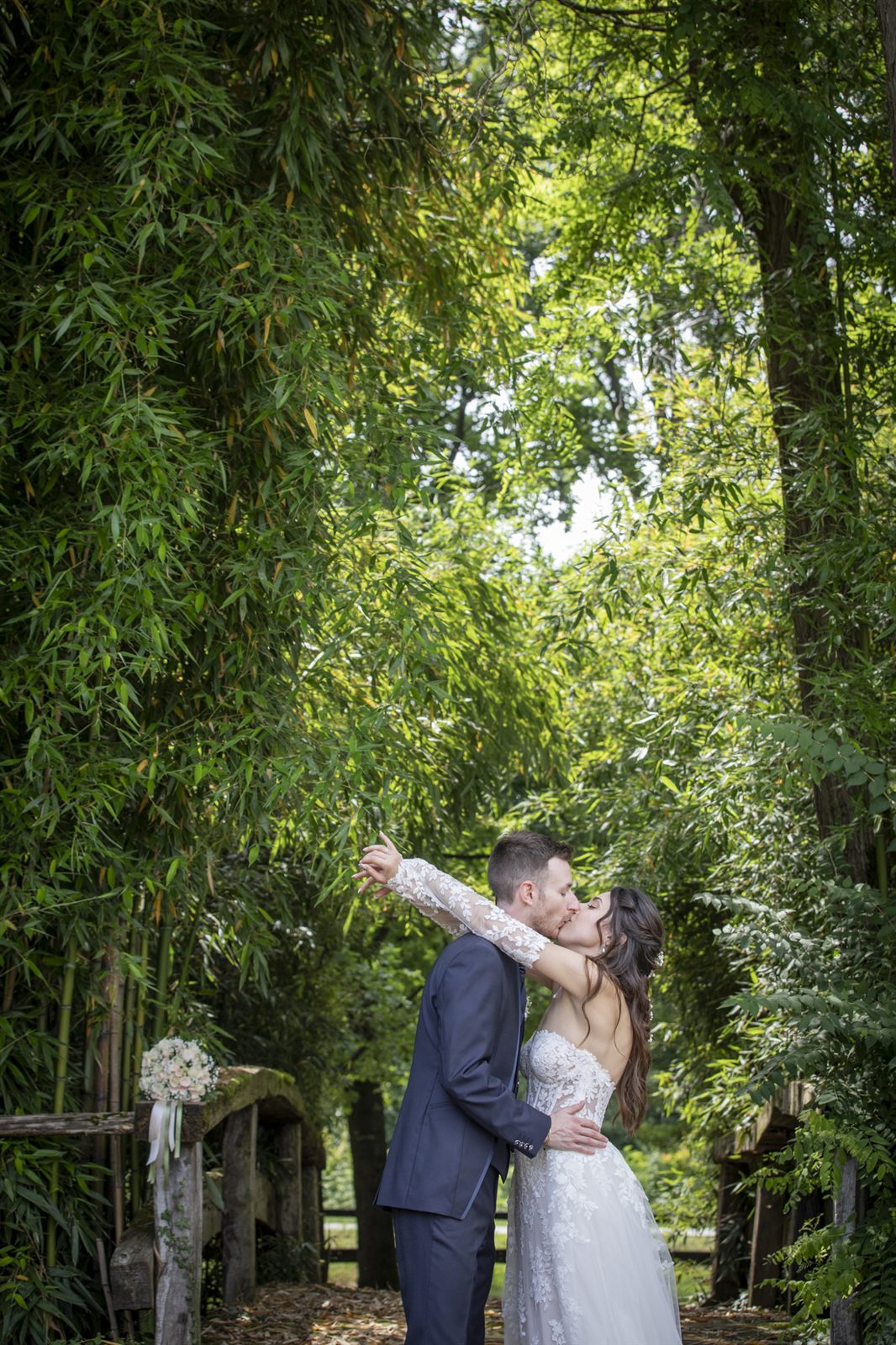 The newlyweds embracing among the green foliage