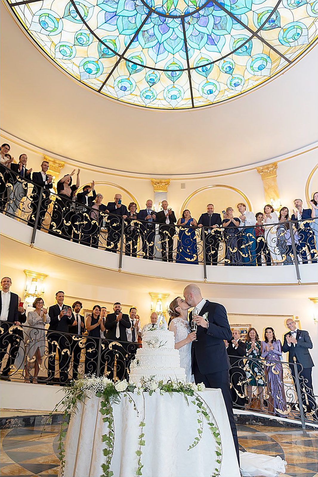 Il taglio della torta sotto la cupola, gli invitati applaudono dai ballatoi