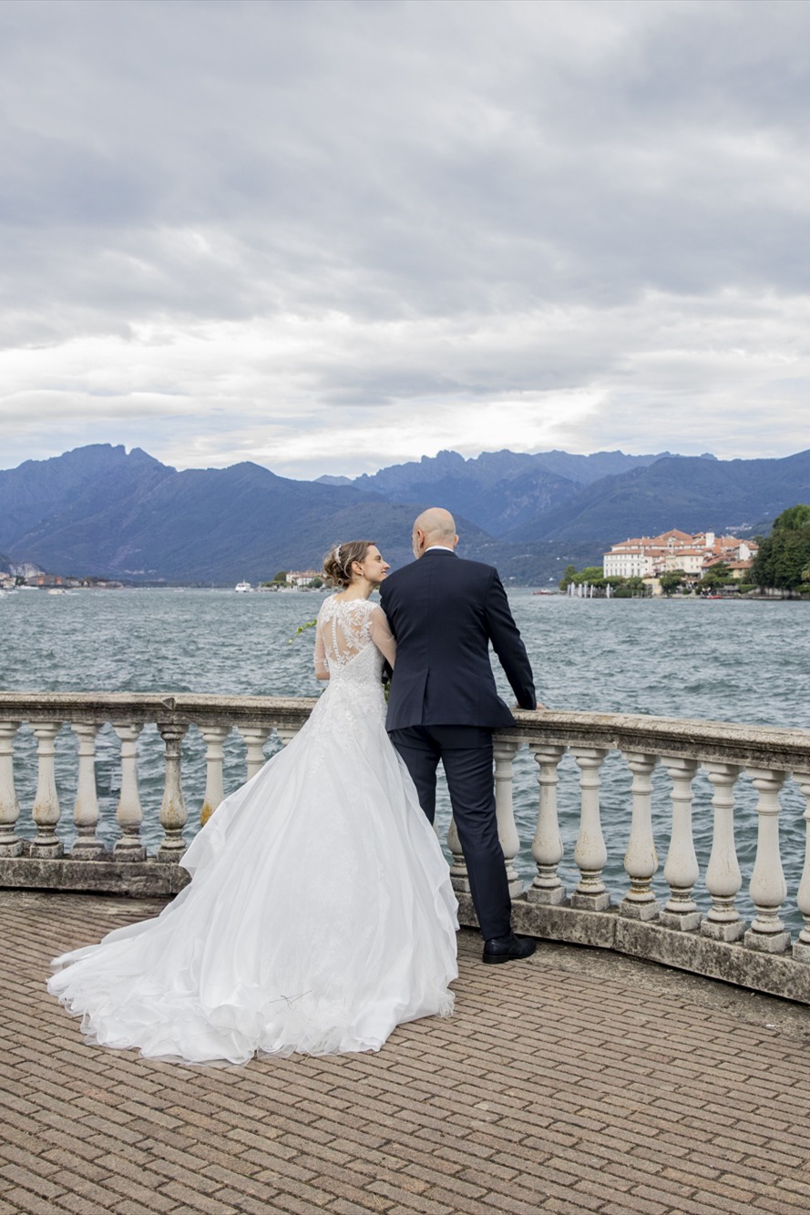 The newlyweds leaning on the balustrade over Lake Maggiore, facing Isola Bella