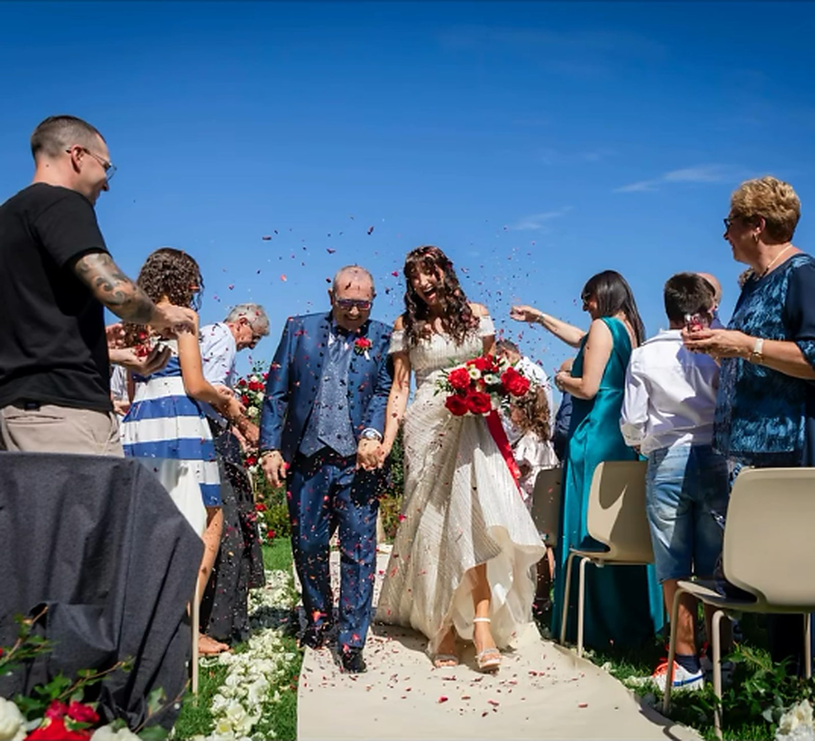 L'uscita degli sposi sotto la pioggia di petali, con il cielo aperto L'uscita degli sposi sotto la pioggia di petali, con il cielo aperto