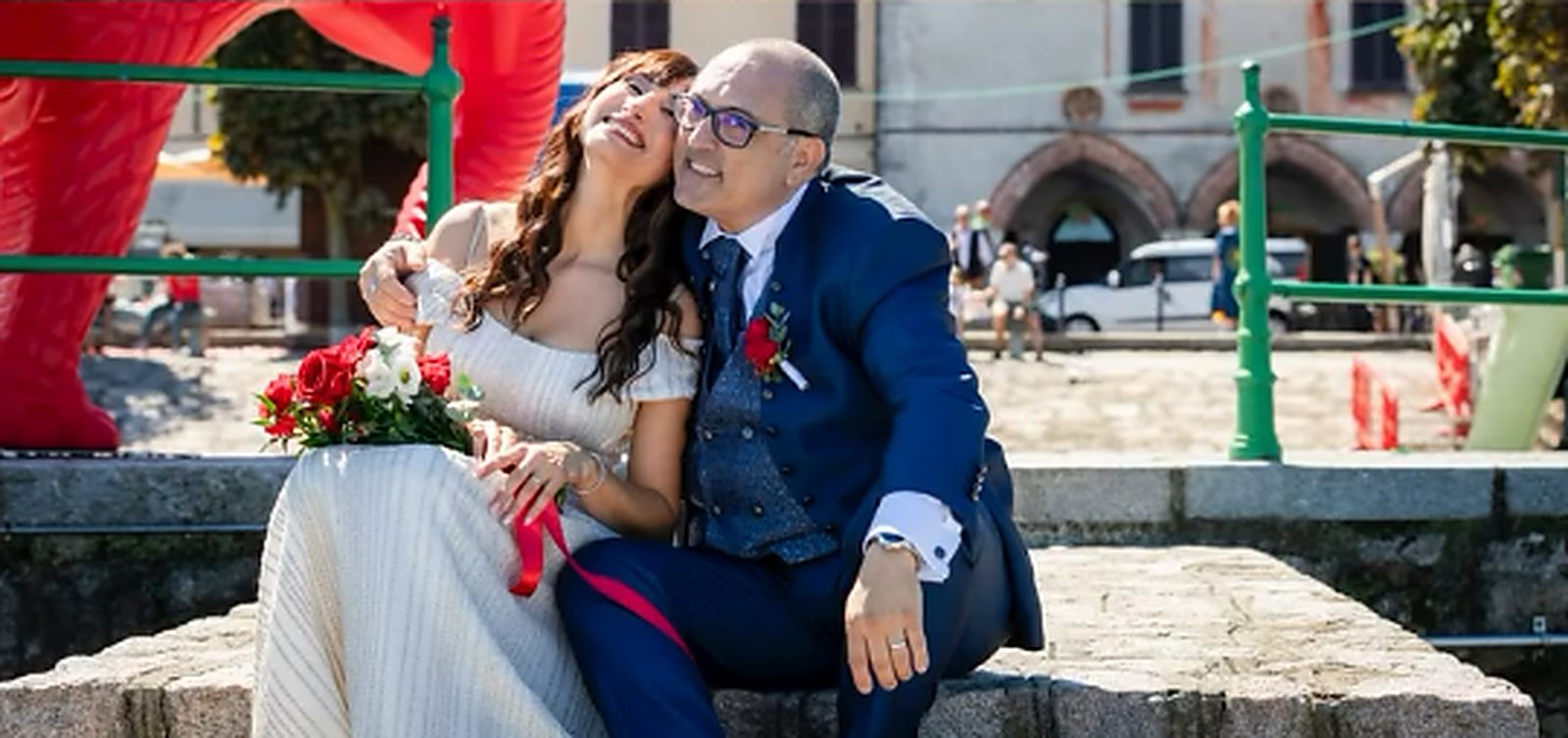 La sposa appoggia la testa sulla spalla dello sposo, seduti sul molo La sposa appoggia la testa sulla spalla dello sposo, seduti sul molo