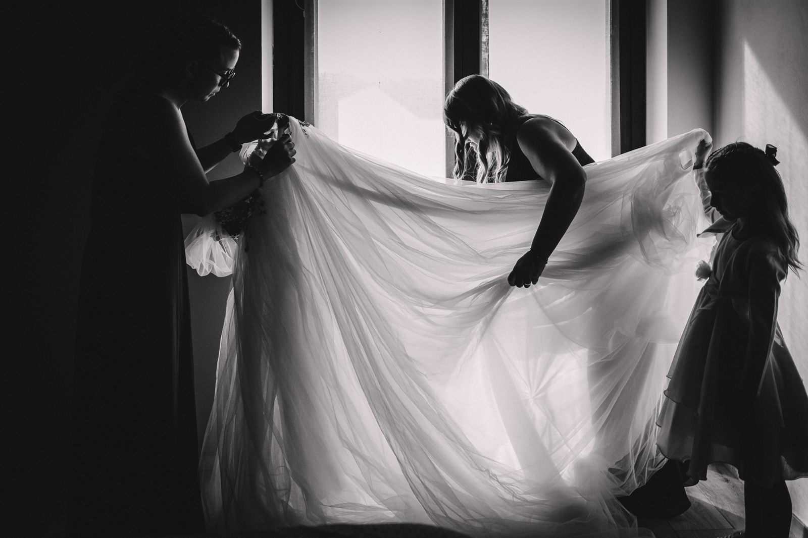 Le damigelle sistemano il velo della sposa, bianco e nero Le damigelle sistemano il velo della sposa, bianco e nero