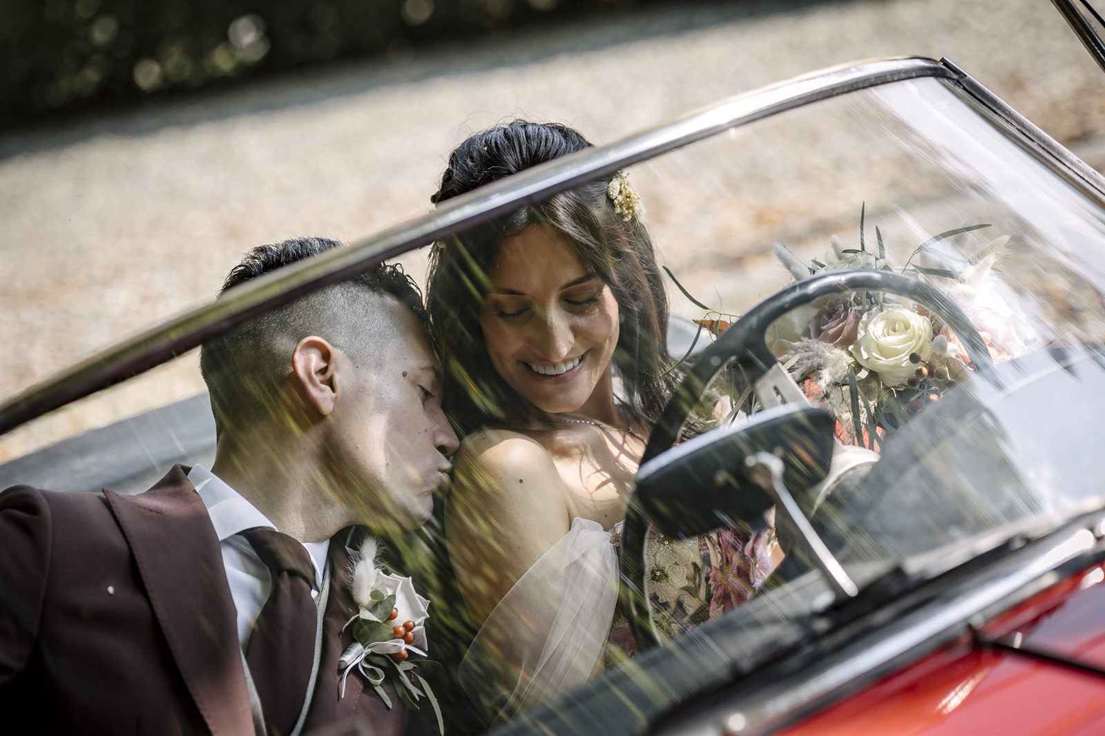 Gli sposi abbracciati nell'auto d'epoca decappottabile Gli sposi abbracciati nell'auto d'epoca decappottabile