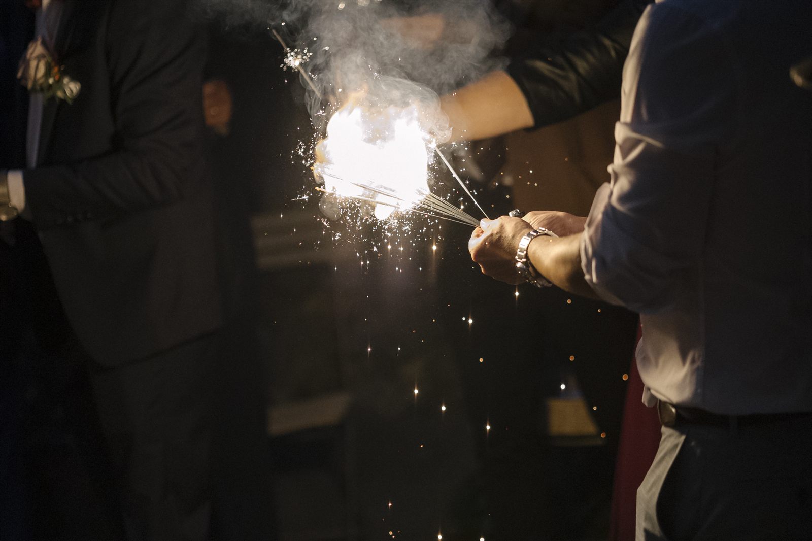 Uno degli sposi accende un fuoco d'artificio da tavolo Uno degli sposi accende un fuoco d'artificio da tavolo