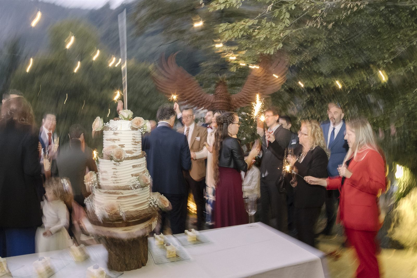 Il taglio della torta tra le luci scintillanti in giardino Il taglio della torta tra le luci scintillanti in giardino