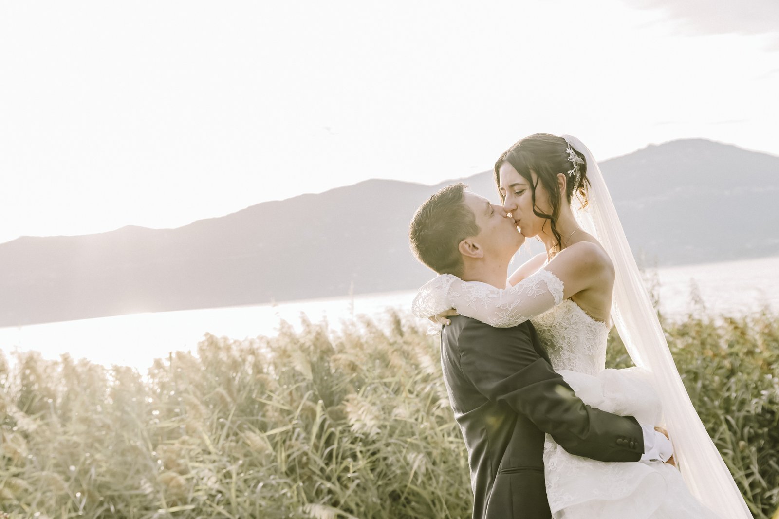 Lo sposo solleva la sposa tra i canneti in riva al lago Lo sposo solleva la sposa tra i canneti in riva al lago