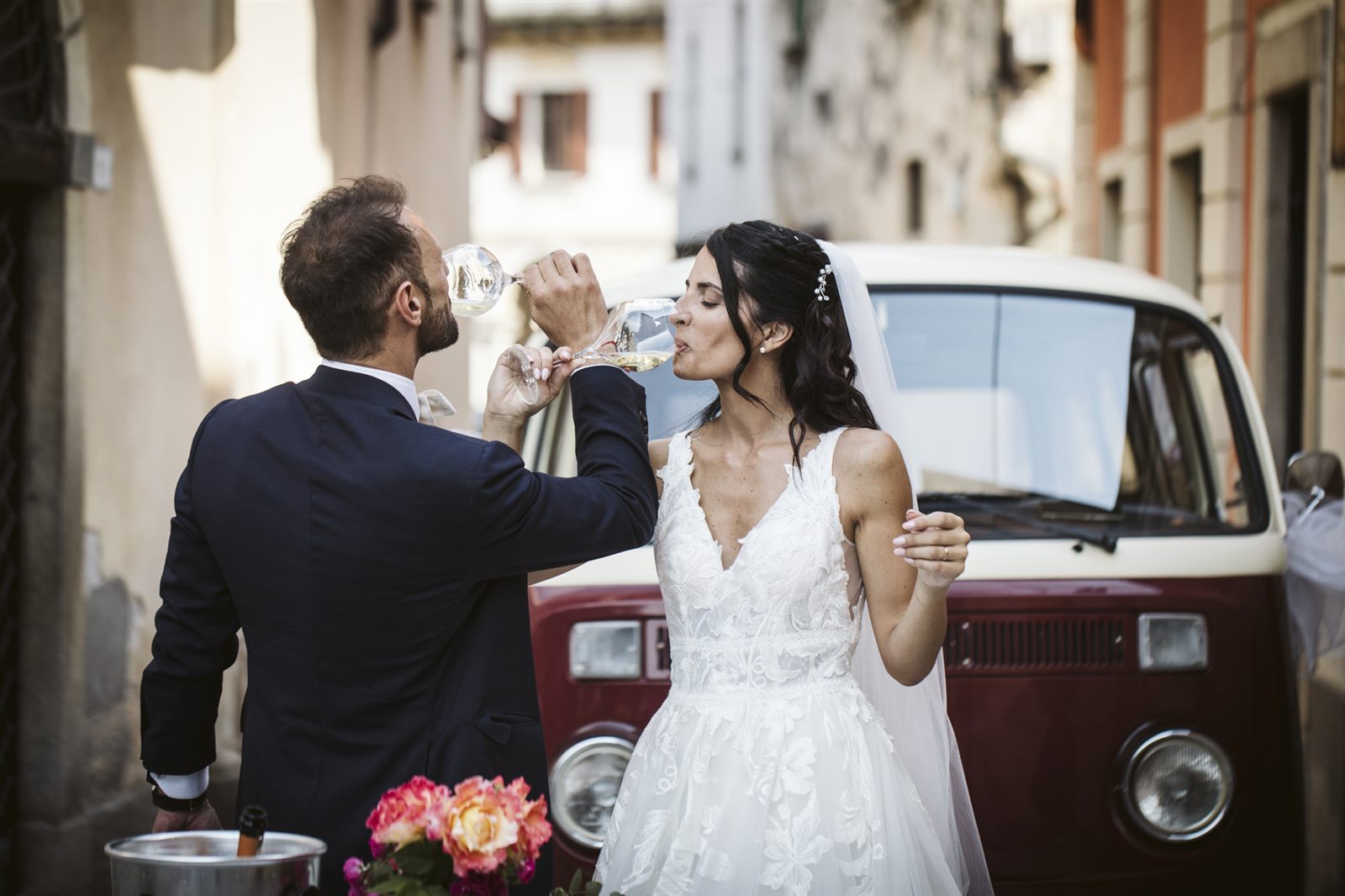 Gli sposi festeggiano accanto al pulmino vintage rosso Gli sposi festeggiano accanto al pulmino vintage rosso