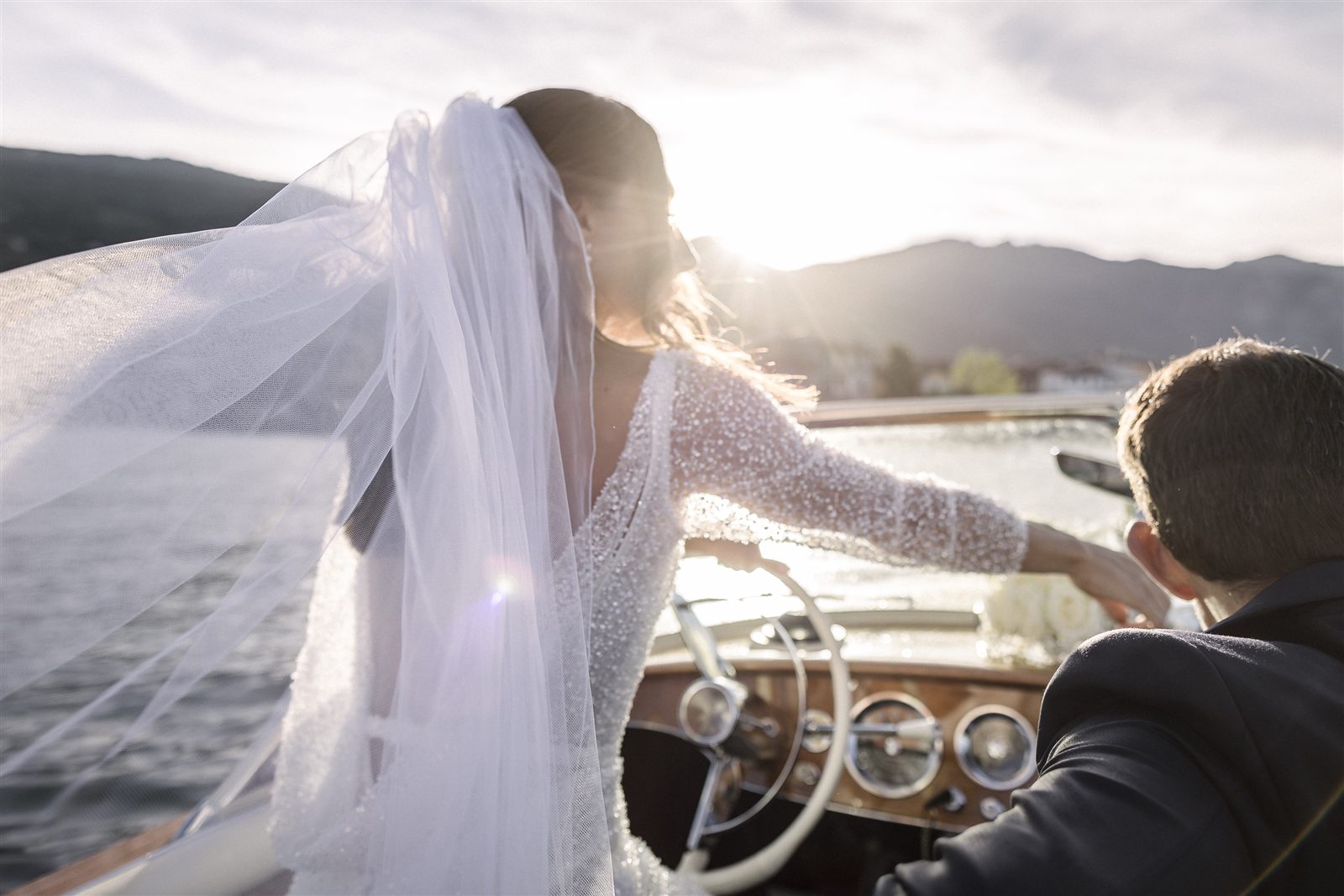 La sposa alla guida del motoscafo d'epoca al tramonto