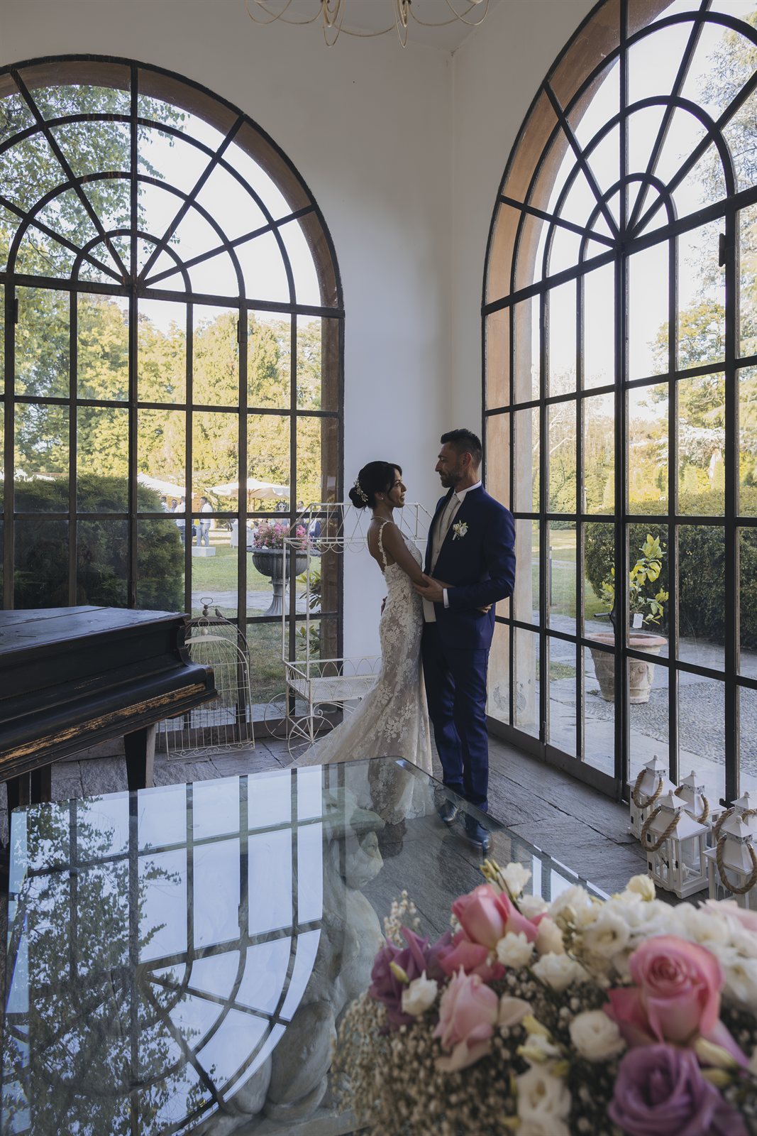 Gli sposi alla grande finestra ad arco, tra i fiori Gli sposi alla grande finestra ad arco, tra i fiori